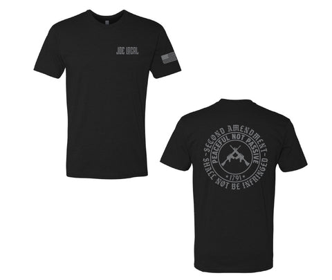 Black cotton short sleeve t-shirt. Joe Local logo on left pocket. The back of the t-shirt has a circular logo saying "second amendment shall not be infringed. Also, within that circle is another circle with the phrase "peaceful not passive, 1791". Within that circle at the center are Two guns in center crossing each other